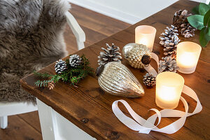 Christmas-tree baubles, pine cones and tealight holders