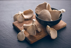 Fresh oyster mushrooms in a bowl and on a wooden board