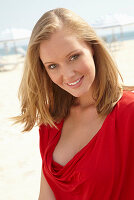 Blonde Frau in rotem Top am Strand