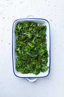 Raw kale with olive oil and spices for kale chips