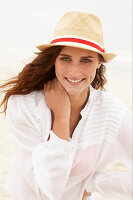 Brünette Frau mit Hut in weißer Bluse