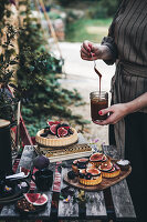 Gedeckter Tisch im Garten mit Feigentartes und Kaffee