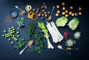 Stilleben mit Gemüse, Salat, Kräutern, Sprossen, Aprikosen und Nüssen