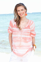 A young woman by the sea wearing a striped blouse