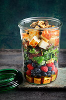 A layered salad with berries and halloumi
