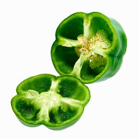 A green pepper with the top sliced in front of white background