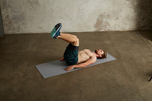 A young man lying on his back with his legs bent up