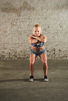 A woman performing a squat with her knees straight