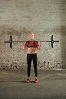 A young woman pressing a barbell