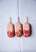 Three pink ice cream sticks with gold leaf