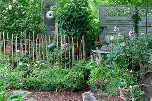 Buchsbaumgarten mit Rosen und Gartendekoration im Shabby Chic