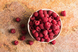 Fresh Raspberries on Napkins in Grass; Picnic Basket