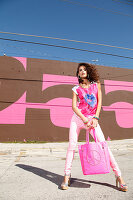 Brünette Frau mit Shopping Bag in pinkfarbenem Top und Hose