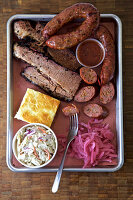 Gemischte Fleischplatte mit Maisbrot, Coleslaw und eingelegten Zwiebeln