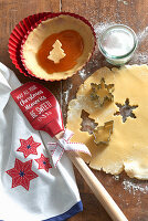 Cookie dough with a cookie cutter and a Christmas themed spatula
