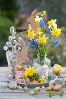 Kleines Oster-Arrangement mit Strauß aus Narzissen und Traubenhyazinthen, Osterhasen und Weidenkätzchen