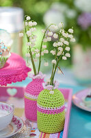 Lily-of-the-valley in vases with crocheted covers in light green and pink