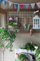 Bunting in front of metal grid on wall used to hang gardening utensils