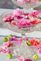 Pale pink and deep pink flowers floating in glass confectionary dish