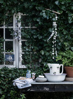 Rustikale Waschstation auf altem Tisch am Gartenhaus mit Efeu