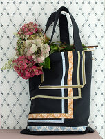 Fabric ribbons sewn-on to a shopping bag with a bunch of hydrangeas