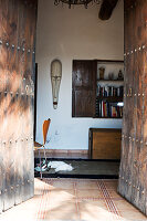 A view through an old wooden door into a Mediterranean house