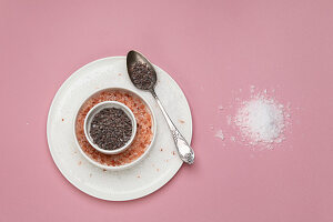 Different types of salt on pink background