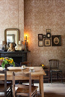 Rustic wooden table and various chairs in front of fireplace