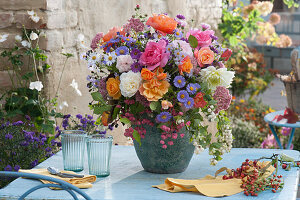 Colorful autumn bouquet of roses, asters, sedum, snowberries, dahlia and European spindle, branch with rose hips