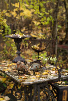 Rustic metal ornaments on old table in autumnal garden