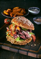 A burger with roast beef, lobster and potato wedges