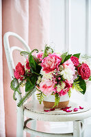 Rosa-weißes Blumenbouquet mit Rosen, Pfingstrosen und Farnblättern