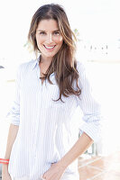 A young woman wearing a light, striped shirt