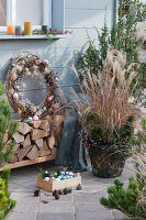 Christmas terrace with Chinese reeds and a wreath of clematis, decorated with fairy lights and balls