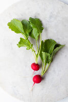Two fresh radishes on a light surface