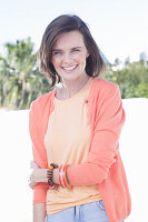 A young woman wearing an apricot top and cardigan