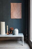Ornaments on bench with marble top against dark blue wall