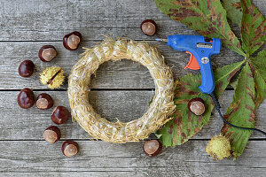 Ingredients for chestnut wreath: straw romans, chestnuts and hot glue gun