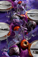 Herbstlich gedeckter Tisch in Lilatönen mit Rotkohl und Kaki