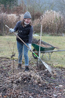 Woman raking up garden waste