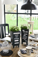 Planters decorated with magazine clippings on set table