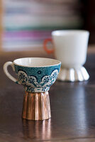Old floral cup on upturned cake tin