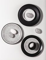 Black and white Easter eggs on black, white and speckled plates