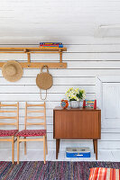 Chairs and cabinet against board wall in rustic wooden house