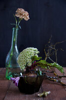 Ungewöhnliche Dekoration mit Knorpelmöhre und Clematis an rote Bete, Nelke in Glasflasche