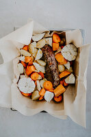Lamb crown with root vegetables in parchment paper