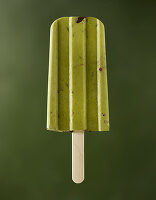 Cashew matcha ice cream on sticks on a green background