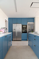 Fitted kitchen with azure-blue cabinets and island counter