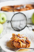 Apple French toast casserole with maple syrup and powdered sugar