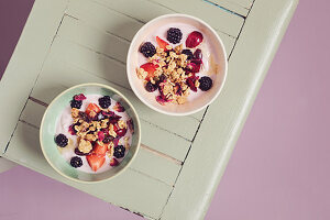 Yoghurt with granola, blackberries, rose petals and cherries